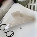 Glossy cream white minimalist hair claw clip for women on a stylish paper background - Jelly White