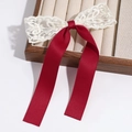 Close-up of handmade cream lace and deep red satin bow hair clip on a velvet tray - Red Lace