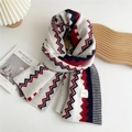 Close-up of wavy knit pattern on a red, navy, and cream scarf with a brand label detail - Double Fold Stripes