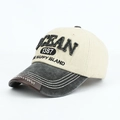 Dettaglio del ricamo OCEAN 3D e visiera vintage su un cappellino da baseball bicolore - Bianco Sporco