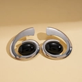 Close-up of silver spiral earrings with oval black gemstones on a beige background - Earrings-Silver (Steel Needle)