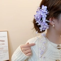 Close-up of purple acrylic flower hair clip with pearls and long tassels on a bun - 26# Duckbill Clip - Purple - Pearl Tassel Silk Flower Single