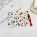 Close-up of quilted floral makeup bag with cat and apple patterns and cotton zipper pull - Cat Angel