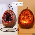 Egg-shaped red agate stone night light on black stand with warm orange glow effect - Dinosaur Egg Night Light - Red Agate