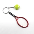 Detailed close-up of a red mini tennis racket and yellow ball keychain charm - 2*9CM / Red