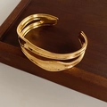 Detail eines unregelmäßigen doppellagigen Goldarmbands mit gewellter Textur-Oberfläche - Gold (Echtgold Vergoldet)
