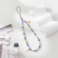 Detail of beaded phone strap with blue crystals and golden star charms on white background - Sapphire Blue