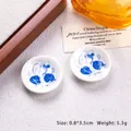 Close-up of miniature blue and white porcelain plates with traditional fish and lotus patterns - Blue White Koi and Lotus Leaf
