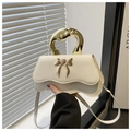 Detail der cremeweißen Handtasche mit unregelmäßigem Goldgriff und Schleifenverschluss - Weiß