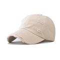 Detail shot of distressed cotton twill baseball cap with frayed hole accents and vintage texture - Beige