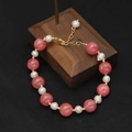 Elegant pearl and pink gemstone beaded bracelet with gold plated clasp on wood stand - Watermelon Red Spaced Freshwater Pearl Bracelet