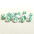 Detail of 10mm white ceramic beads with green floral pattern on textured fabric - 10mm / Green Small Plum Blossom