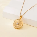 Golden stainless steel necklace with sunburst pearl pendant on white display base - Sunburst Round Pearl Style (137605)