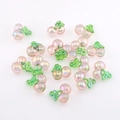 Makrofoto von rosa schimmernden Kirsch-Anhängern mit grünen Blättern für DIY-Schmuck - AB Aurora Pink Kirsche