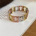 Detail of tricolor cross cutout stretch bracelet with textured finish on book - 5# Three-Tone Hollow Cross Metal Bracelet