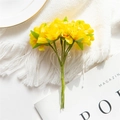 Artificial yellow flower bouquet with green leaves on a white fringe knitted blanket - Yellow