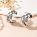 Detail view of double-layered silver C-shape earrings with high-polish mirror finish - Stud Earrings / Silver