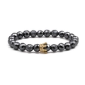 Detail view of multifaceted grey stone beads and a gold crown pendant with tiny gems - Gold Crown