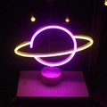 Saturn-shaped LED neon sign with purple and yellow glow on a white cylindrical base - New Bicolor Earth/Saturn