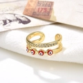 Double layer gold evil eye ring with red enamel and pavé zircons on white fabric - Red Eyes Style