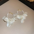 Dettaglio di orecchini a cerchio dorati con perle bianche e petali di fiori in resina - Perno in argento-Bianco