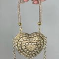 Sparkling gold heart evening bag with diamonds and chain strap shown in a hand - Gold Heart Bag with Triangle Crystals