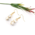 Detail von golddrahtumwickelten Ohrringen mit weißen Perlen im Marmordesign und Boho-Stil - Gold + Weißer Türkis