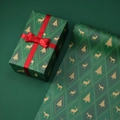 Green Christmas kraft wrapping paper with gold deer and tree patterns on a gift box - Elk Christmas Tree