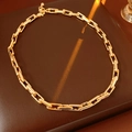 Detailansicht einer goldfarbenen Gliederkette auf einem warmen braunen Hintergrund - Gold