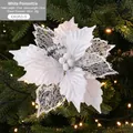 White poinsettia artificial Christmas flower with glitter detail on a warm lit tree - White