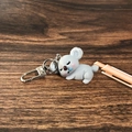 Llavero de koala durmiendo en resina gris sobre un fondo de madera oscura - Koala durmiendo / Gris