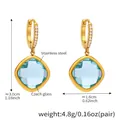 Détail de boucles d'oreilles en acier doré avec verre tchèque bleu clair et zircon - Or Verre Bleu Clair