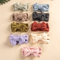 Flat lay of nine colorful double-layered knitted bow headbands for babies in assorted tones - Random Color