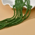Detailed view of faceted 4mm green glass wheel beads for DIY jewelry making - Leaf Green