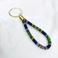 Bohemian ethnic style woven wrist strap keychain with gold metal ring on white fabric - Multi-Color Braided