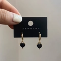 Primer plano de pendientes de corazón dorados con piedras de circonita negra pulida - Negro/Dorado / Poste de Pendiente