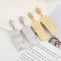 Detail showing gold and silver rectangular earrings with industrial rippled texture - Gold EH007 (Wave Rectangle)