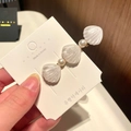 Handheld view of a mermaid style hair clip with white shells and pearls on a card - 4# Pearl Shell - White