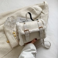 White plush trimmed handbag with gold hardware and shoulder strap in a stylish setup - White