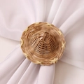Close-up of straw woven hat-shaped napkin ring on white fabric with natural texture - Hat Shape