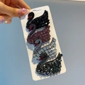 Detailed close-up of four swan-shaped hair clips with sparkling rhinestones in multiple colors - Swan