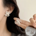 Silver spiral windmill stud earring with center white pearl shown on a model - Silver Spiral Pearl Pinwheel Studs (ED2596)
