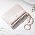Mini monedero rosa con cremallera dorada y llavero sobre fondo blanco minimalista - Blanco Roto