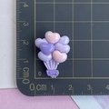 Vue détaillée de breloques cœur en résine avec gravure LOVE sur tapis gradué - Ballon Violet