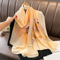 Elegant peach long silk scarf with purple and brown leaf prints hanging on a hanger - 90*180cm / Orange