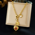Collana dorata con ciondoli a cuore e girasole, cristalli rossi e bianchi su portagioie - Multi-Ciondolo Oro (N3577)