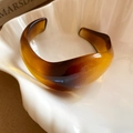 Close-up van amberkleurige hars manchetarmband met schildpadtextuur op een schaal - 3# V-Vorm Koffie Stijl (3#手镯-咖色-V形)