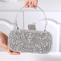 Detail der silbernen Abendtasche mit floralen Strassmustern und elegantem Metallgriff - Silber