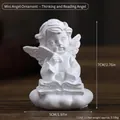 White resin angel figurine reading on a cloud base for minimalist desk decor - Mini Propping Chin Reading Angel