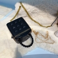 Vista dall'alto di una mini borsa a secchiello nera borchiata con catena dorata su peluche - Nero
